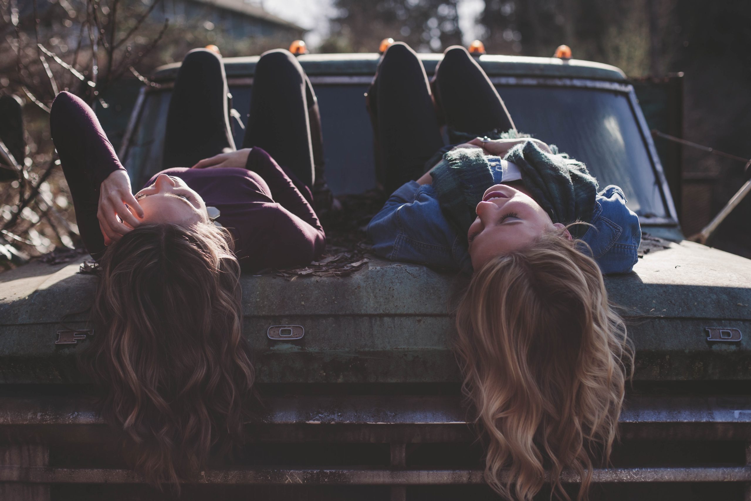 two women lying on a truck